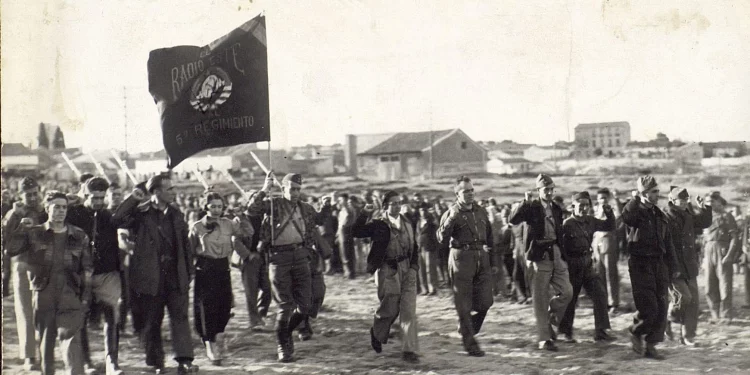Desfile con Enrique Líster en Hortaleza en la entrega de una bandera de Radio Este al 5º Regimiento y formación del batallón Enrique Líster. Fuente: Ministerio de Cultura